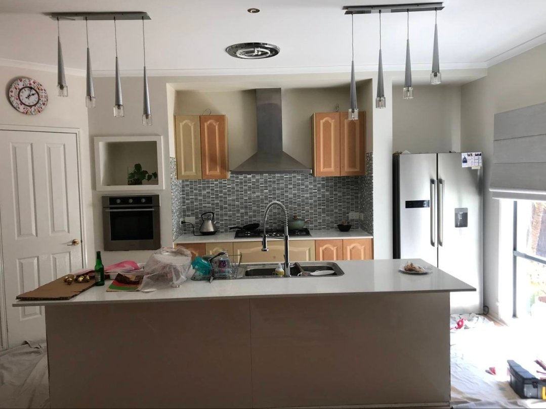Before open-plan kitchen makeover photo showing timber-toned cabinetry and an older island finish